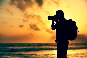 Photographer on the beach at sunset