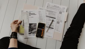 Person reviewing a settlement check and financial documents