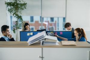 Contemporary office setting with employees working at their cubicles.