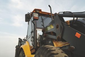 An excavator against a clear sky at a construction site.