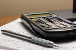 Close-up of business insurance policy documents next to a laptop and a calculator