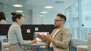 An adviser and a business owner discussing insurance cover across an office desk